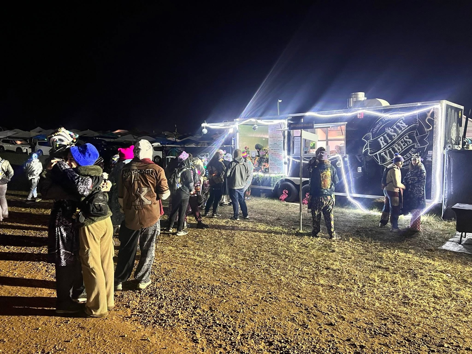 Risin’ Vibes Kitchen trailer serving guests at a nighttime event.